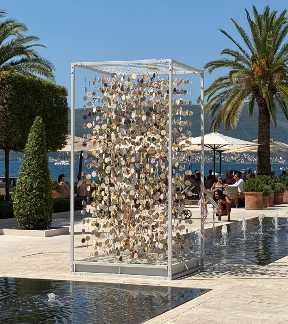 Art object: a steel frame with suspended discs by the water